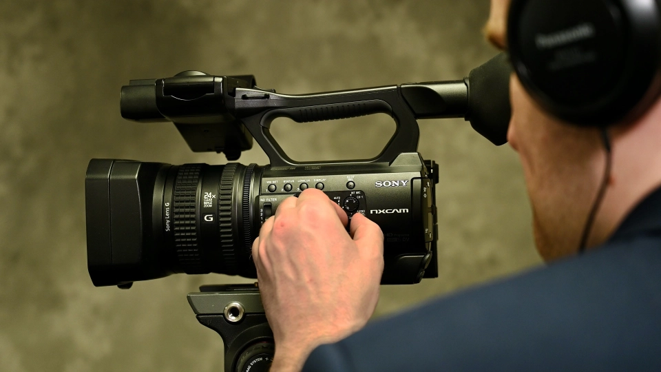 Legal Videographer A legal videographer adjusting settings on their camera.